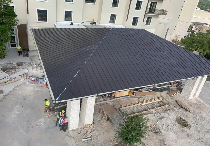 Metal roofing installation team working on a commercial building in Corsicana